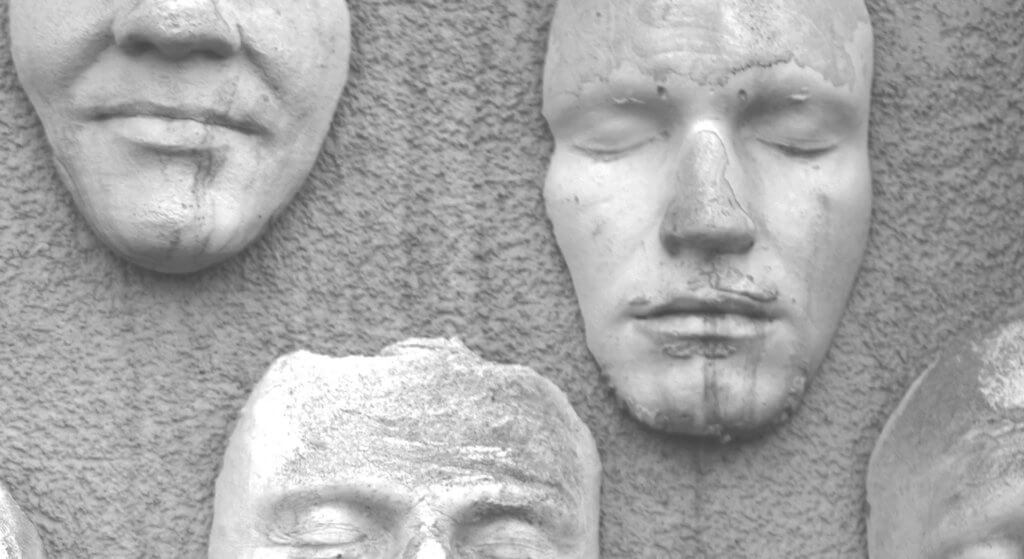black and white photograph of a wall of different facecasts.