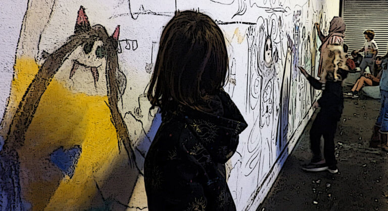 A child is drawing a life-size character on a white wall in the foreground. Other people in the background are doing the same.