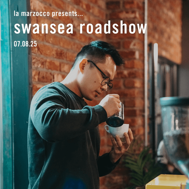 A man pouring milk into a coffee cup to make latte art.